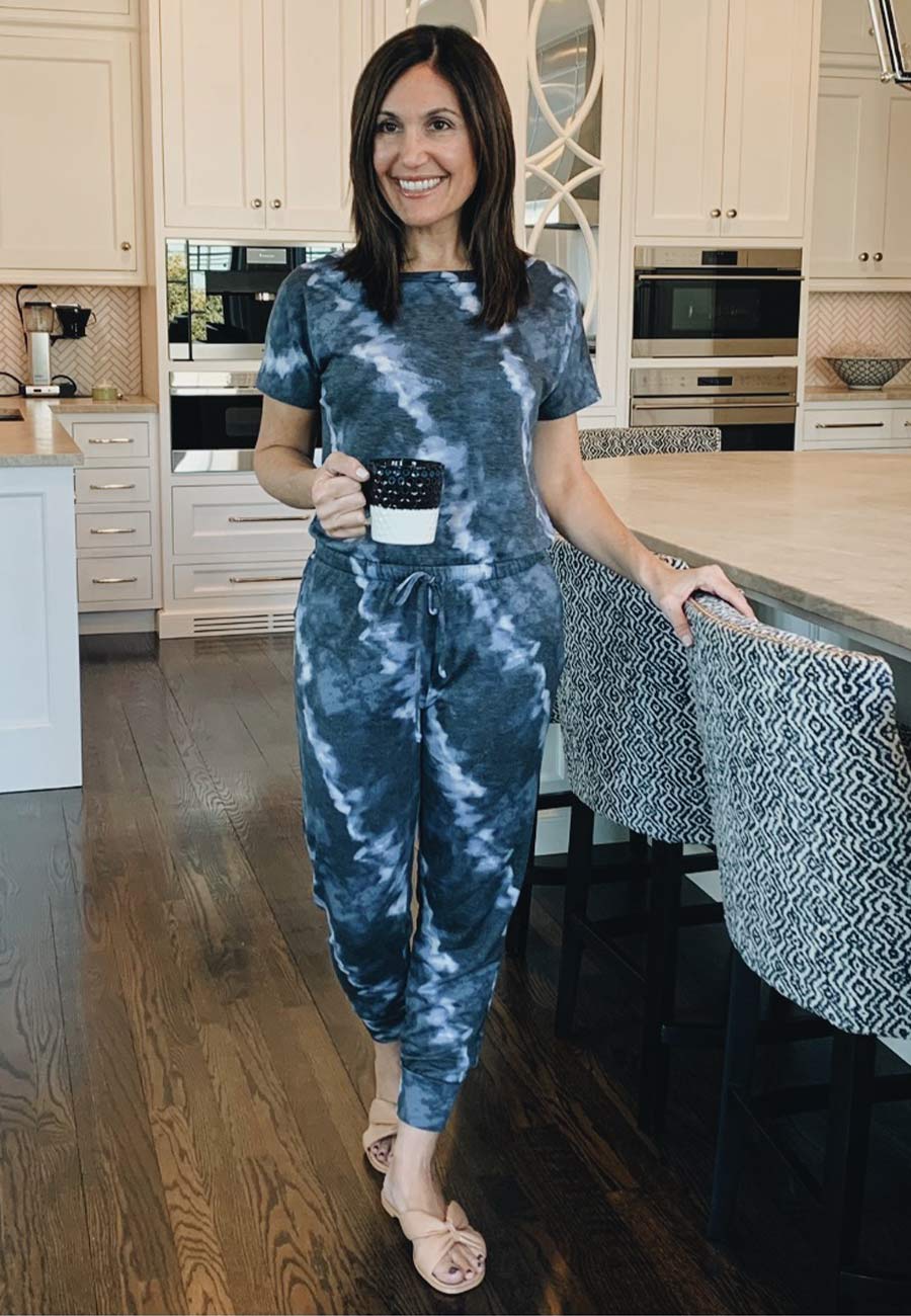 Alysia in tiedye jumpsuit holding a mug