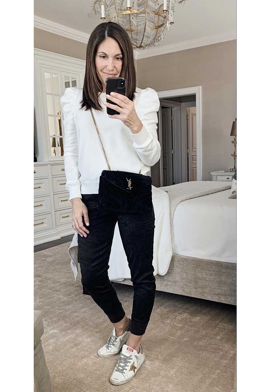 Alysia wearing white shirt with puffy sleeves, black pants, and white sneakers